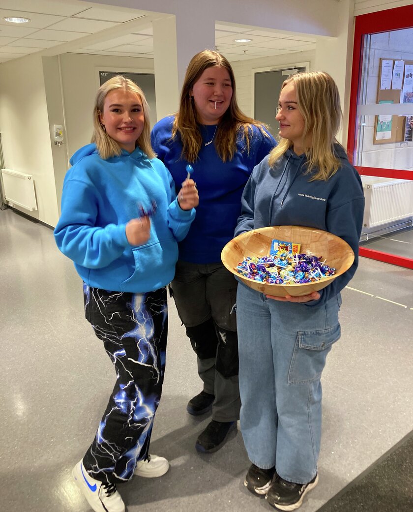3 jenter med godteri står og smiler  - Klikk for stort bilde