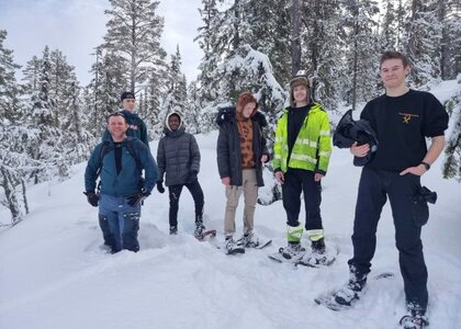 6 personer med truger på beina inni en snørik skog - Klikk for stort bilde